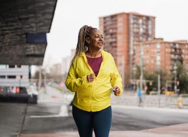 Woman jogging through a city.