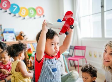 A little boy playing with a toy airplane.