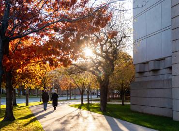 Two individuals walking beside Robarts Library.